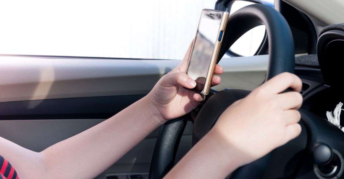 femme qui utilise son smartphone au volant et le manipule