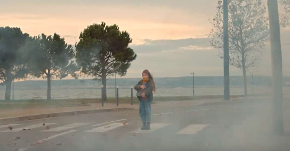 Jeune fille à pied à l'arrêt sur un passge piéton