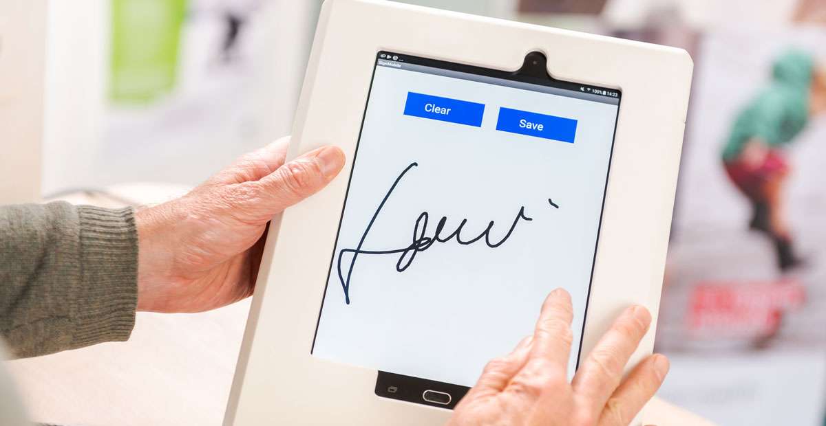 une personne signe sur une tablette