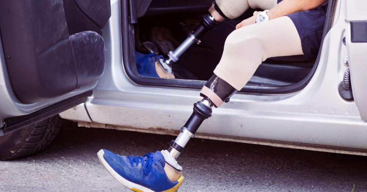 homme handicapé qui monte dans son véhicule en pliant sa chaise roulante
