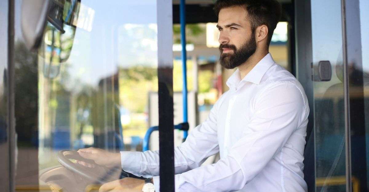 conducteur de bus qui regarde derrière lui