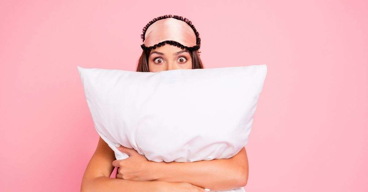 Femme insomniaque qui tient un oreiller dans ses bras