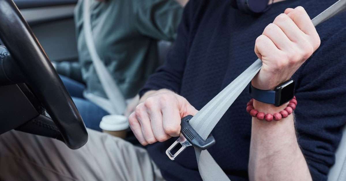 jeune homme conducteur qui met la ceinture de sécurité