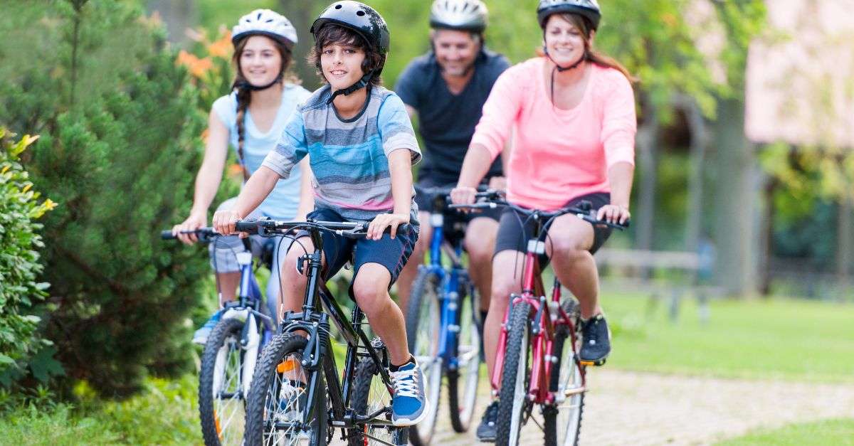 famille à vélo en ville portant des casques