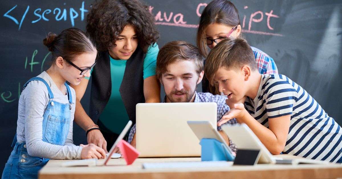 enseignant souriant en classe numérique