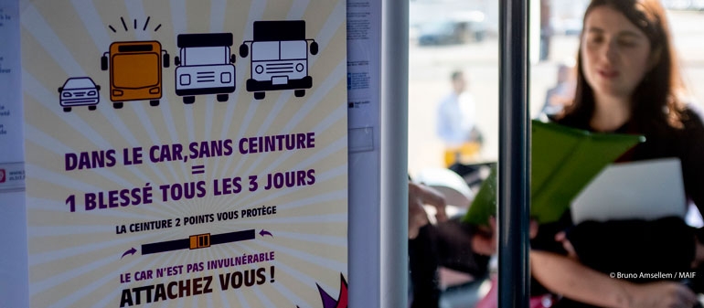 Affiche dans un car scolaire pour convaincre de porter la ceinture de sécurité