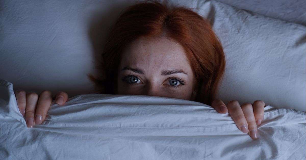 femme qui se cache sous une couette