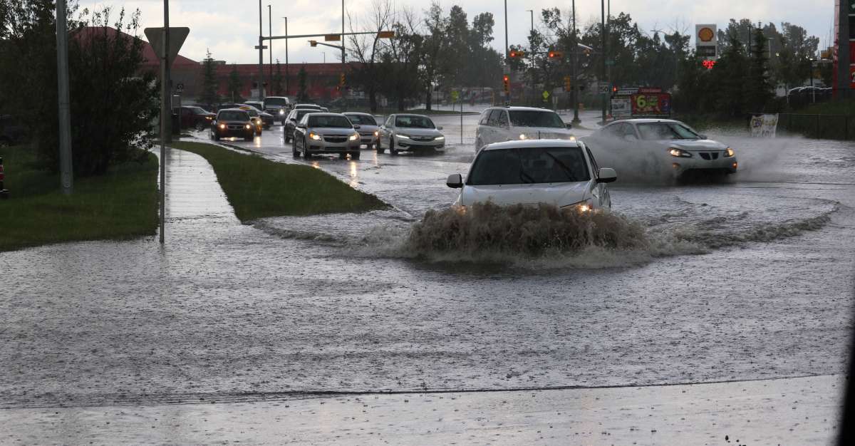 route inondée avec des voitures qui roulent dans l'eau