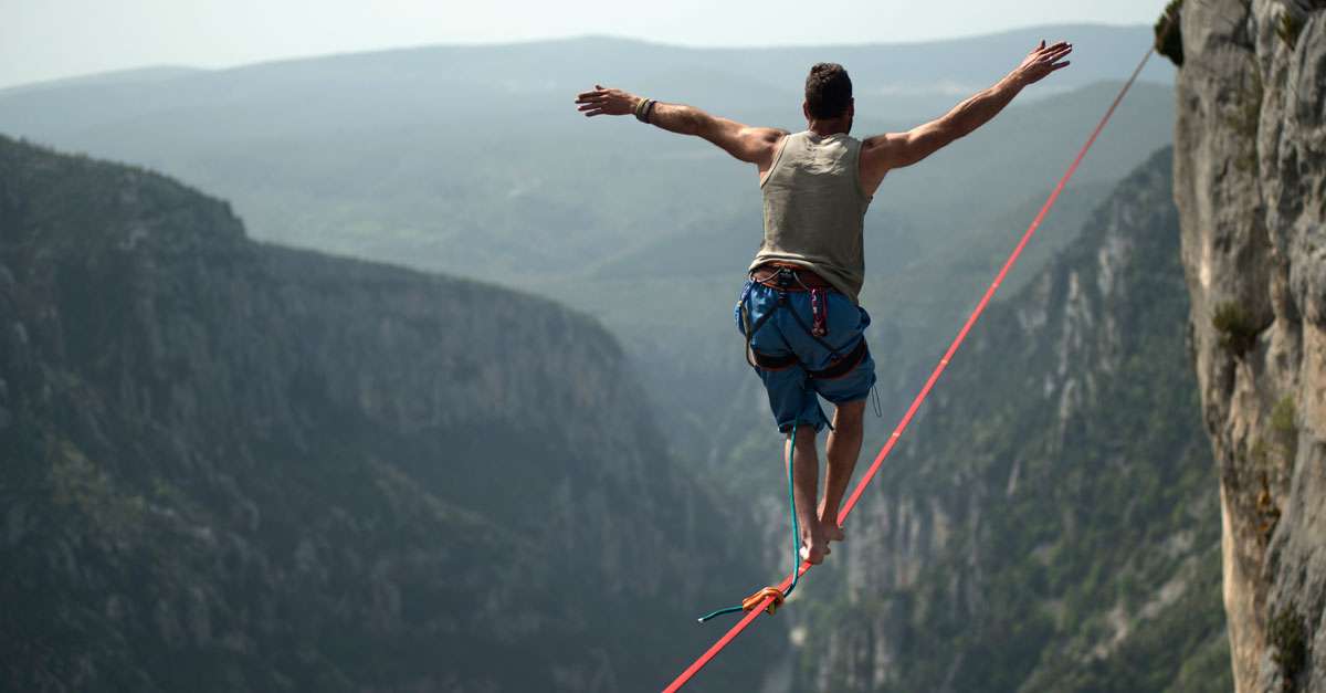 homme funambule entre deux montagnes