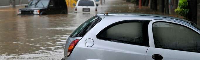 Sacs de sable et batardeaux devant une porte d'entrée rouge contre les inondations