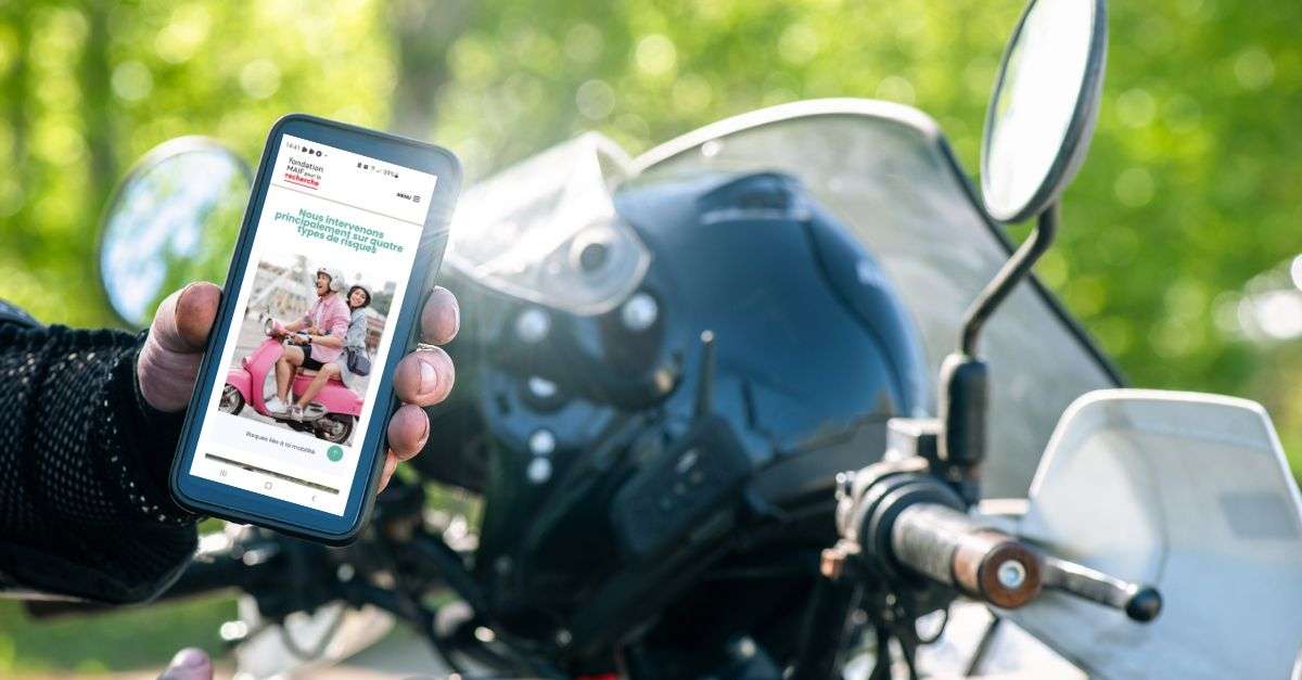 Motocycliste qui tient son smartphone à la main