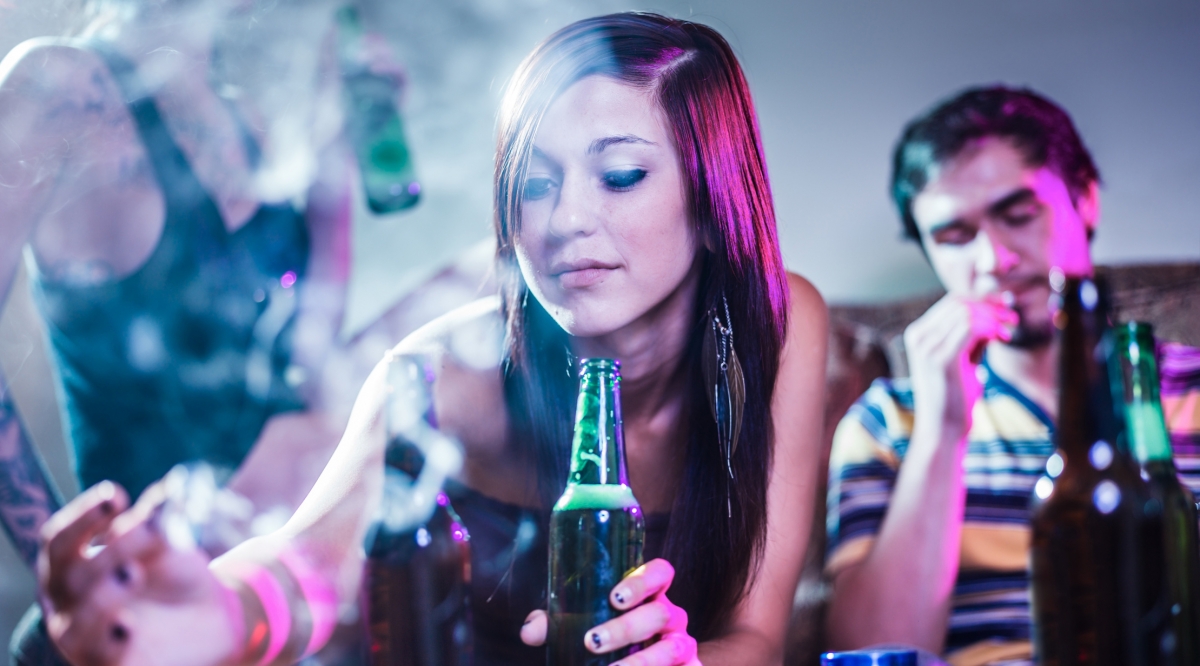 les jeunes personnes en train de fumer et de boire lors d'une fête