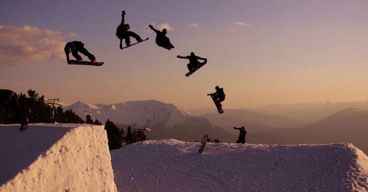 Snowboadrer qui fait un tour magnifique en snowpark