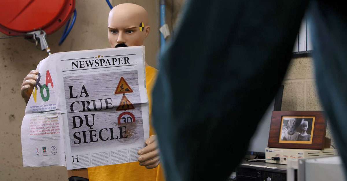 Didier le crash test dummy lit un journal avec la crue du siècle à la une